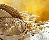 Unbaked wholemeal bread in baking tin, ingredients at side