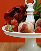 Fresh strawberries and peaches on pedestal stand