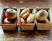 Frische Äpfel und Kartoffeln in Spankörben