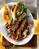 Lamb kebabs with fried chicory and olives