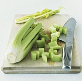 Celery, partly sliced, on chopping board