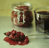 Cranberry sauce on spoon and in jars