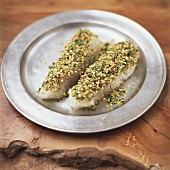 Fish fillets with herb crust on pewter plate