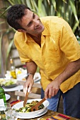 Man preparing barbecued courgette strips