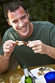 Man eating barbecued chicken leg