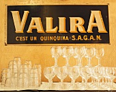 Leere Wein- und Wassergläser vor Valira-Werbeschild