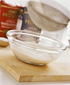 Sieving flour into glass bowl