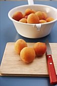 Apricots on chopping board and in strainer