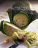 Savoy cabbage, partly sliced, and half an onion