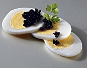 Sliced boiled eggs with caviare and parsley