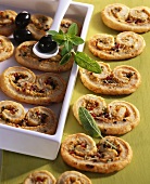 Puff pastry 'pig's ears' filled with cheese, ham, olives
