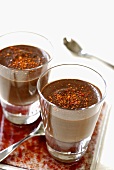 Schokoladencreme, mit Chilipulver bestreut, in Gläsern