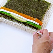 Making California rolls (rolling up bamboo mat)