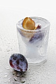 Ice glass with clear schnapps and plums