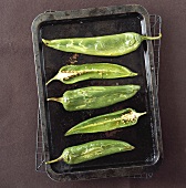 Roasted green pointed peppers on baking tray