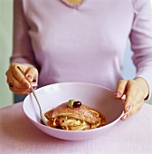 Woman eating red mullet with ribbon pasta