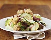 Salad leaves with pork cheeks, cucumber and radishes