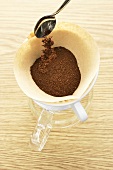 Kaffeepulver in Kaffeefilter schütten