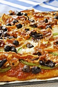 Pancetta and pepper pizza with olives (detail)