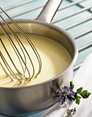 Béchamel sauce in pan with whisk