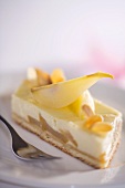 Piece of cheesecake topped with pears and flaked almonds