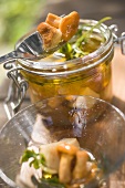 Pickled mushrooms in a jar and on fork