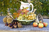 Sweet chestnuts, grapes, apples and autumn leaves