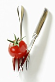Cherry tomato on crossed knife and fork