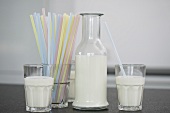 Milk in glasses and bottle, straws