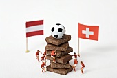 Pieces of chocolate, football, toy footballers, flags