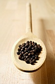 Peppercorns on wooden spoon