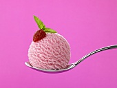 A scoop of raspberry ice cream on a spoon