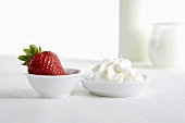 Fresh strawberry and cream in small dishes, yoghurt, milk