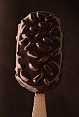 Chocolate-coated ice cream with almonds on a stick