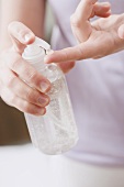 Woman squeezing gel out of a bottle on to her finger