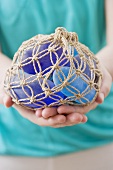 Woman holding blue stones in string net