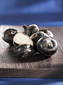 Water chestnuts, whole and halved, on wooden board