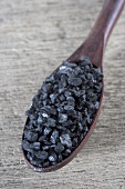 Black salt on wooden spoon