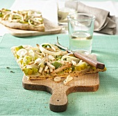 Piece of leek pizza on chopping board