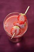 Strawberry smoothie with frozen strawberry skewer