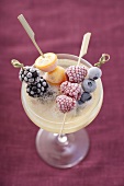 Frozen fruit skewers in a saucer of champagne