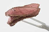 Slices of beef steak on carving fork