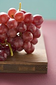 Red grapes on chopping board