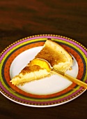 Piece of lemon tart on plate with spoon