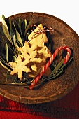 Christmas biscuits and candy cane in wooden bowl