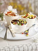 Drei verschiedene Salate mit Dressings in Schalen auf Teller