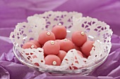 Pink marzipan balls with silver dragees on doily