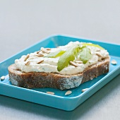 Cheese spread, sunflower seeds and rocket on bread