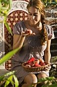 Frau mit Pfirsichen auf Gartenstuhl