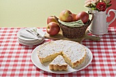 Apple tart with icing sugar, a piece cut